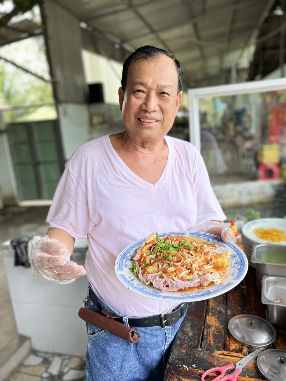 Ông Huỳnh Hữu Hoài với món pizza hủ tiếu độc quyền. (Ảnh: TTXVN phát)