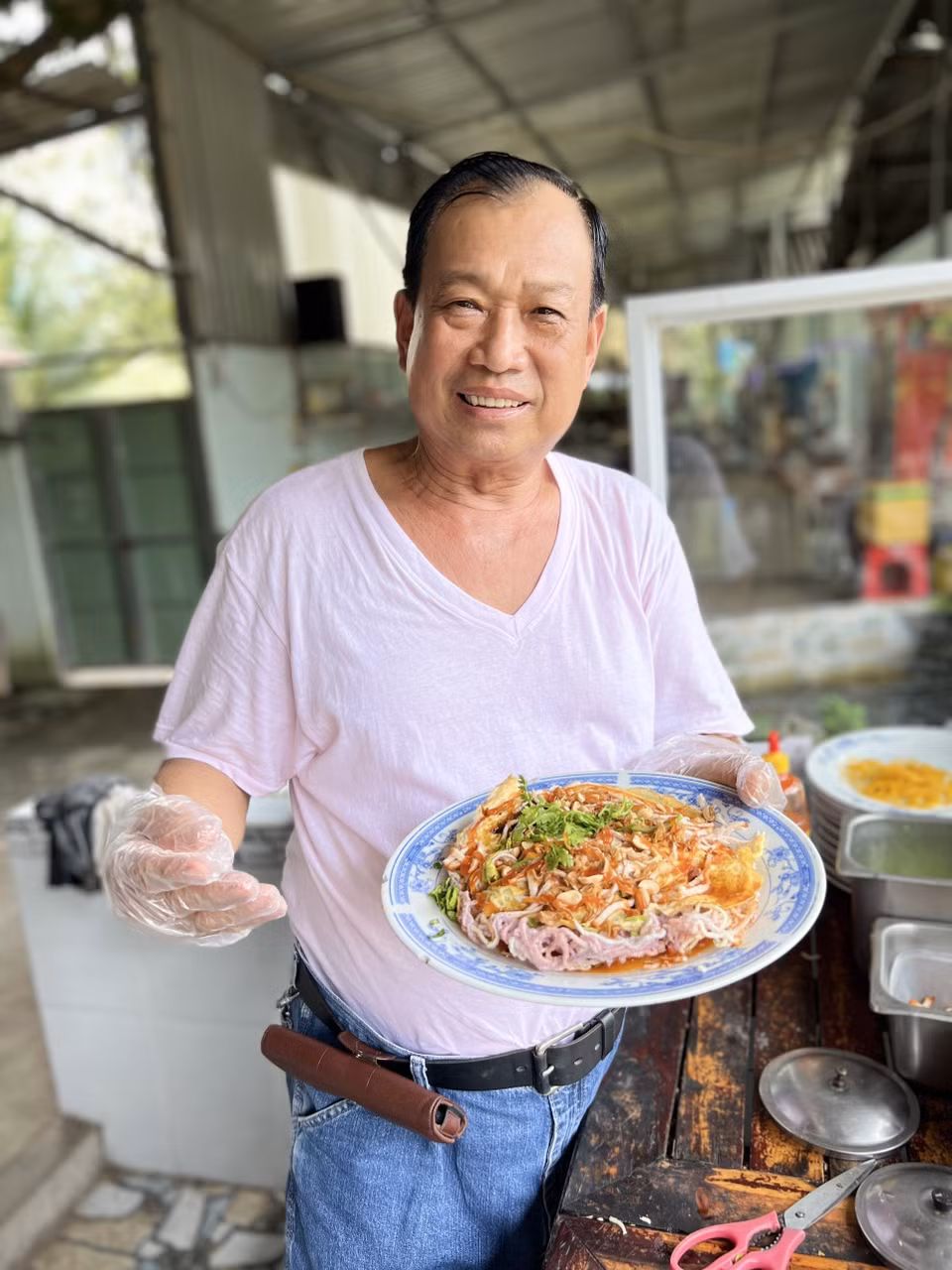 Ông Huỳnh Hữu Hoài với món pizza hủ tiếu độc quyền. (Ảnh: TTXVN phát)
