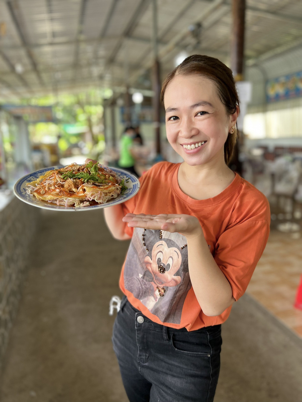 Du khách với món pizza hủ tiếu độc quyền của lò hủ tiếu Sáu Hoài. (Ảnh: TTXVN phát)