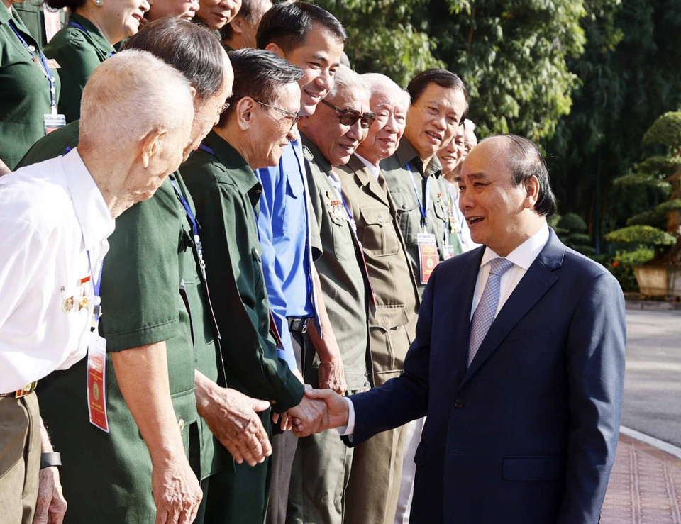 Nhân dịp kỷ niệm 75 năm Ngày Thương binh-Liệt sỹ, sáng 26/7/2022, tại Phủ Chủ tịch, Chủ tịch nước Nguyễn Xuân Phúc gặp mặt thân mật Đoàn đại biểu Hội Cựu thanh niên xung phong. (Ảnh: Thống Nhất/TTXVN) 