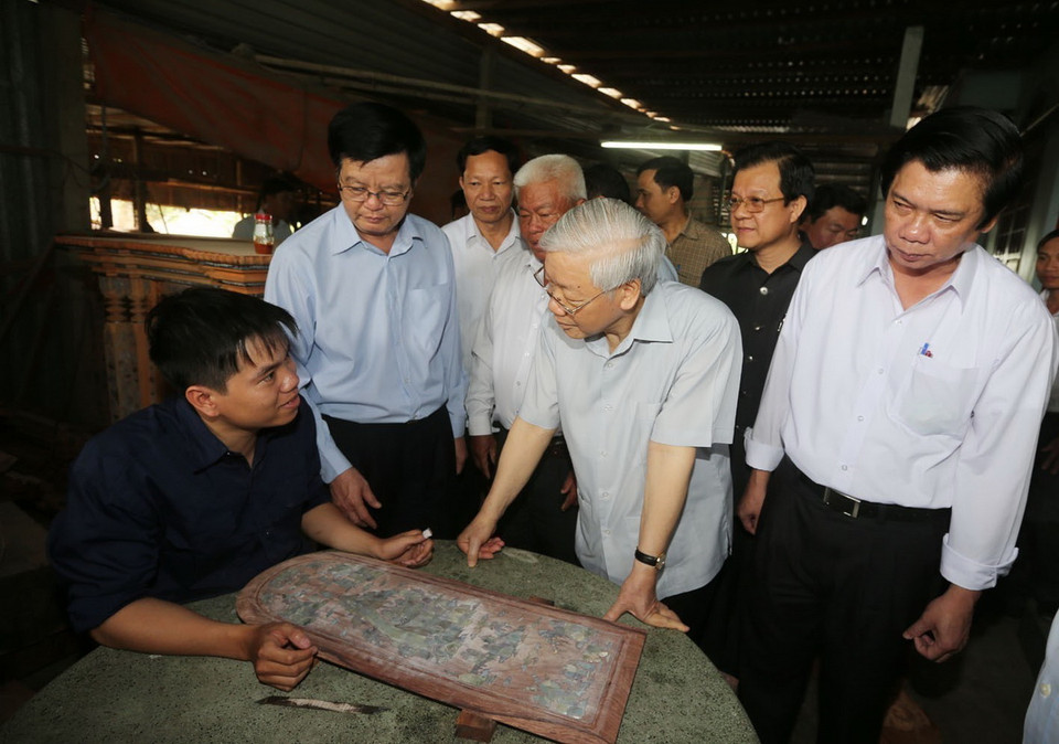 Tổng Bí thư Nguyễn Phú Trọng thăm hỏi công nhân làng nghề sản xuất gỗ truyền thống Gò Công, xã Tân Trung, thị xã Gò Công, huyện Gò Công Đông, tỉnh Tiền Giang, sáng 16/3/2016. (Ảnh: Trí Dũng/TTXVN)