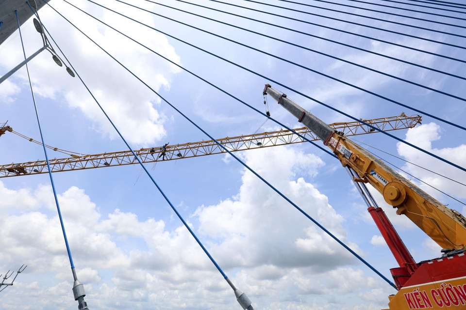 Các nhà thầu đang khẩn trương tháo dỡ các trụ tháp tại cầu Vàm Cống trước ngày thông xe. (Ảnh: Huy Hùng/TTXVN)