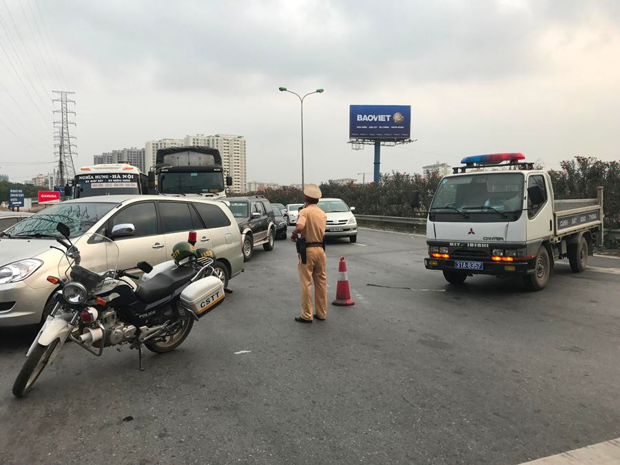 Lực lượng Cảnh sát giao thông phân luồng bằng cách cho phương tiện vòng qua đường Tam Trinh rồi mới vào đường Giải Phóng. (Ảnh: Việt Hùng/Vietnam+)