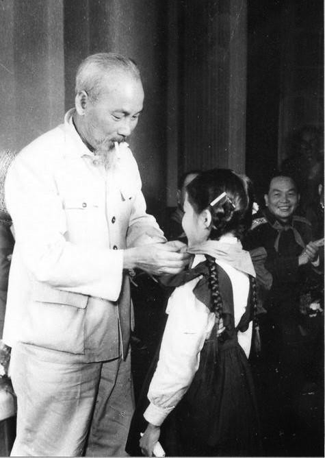 Bác Hồ quàng khăn đỏ cho một đại biểu thiếu nhi Thủ đô tại Phủ Chủ tịch khi các cháu đến chúc tết Người nhân dịp xuân Canh Tý, ngày 28/1/1960. Cháu gái đã vinh dự được Bác Hồ quàng khăn đỏ tên là Nguyễn Thị Đỉnh, học sinh lớp 6 trường cấp II Trưng Vương, Hà Nội. (Ảnh: Tư liệu TTXVN)