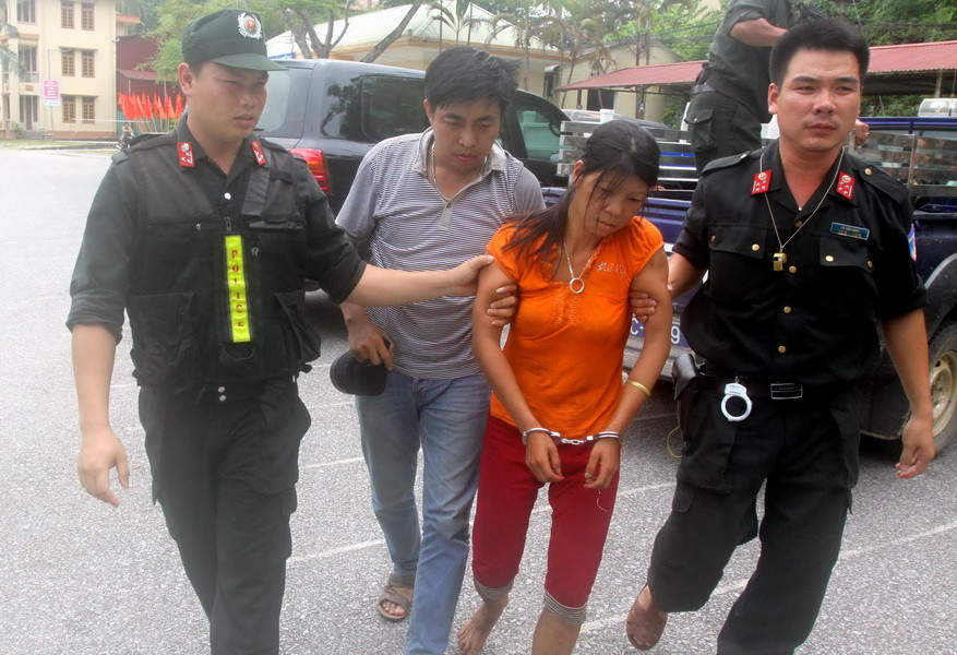 Lực lượng công an áp giải nghi can Nguyễn Thị Hán. (Ảnh: Thế Duyệt/TTXVN)