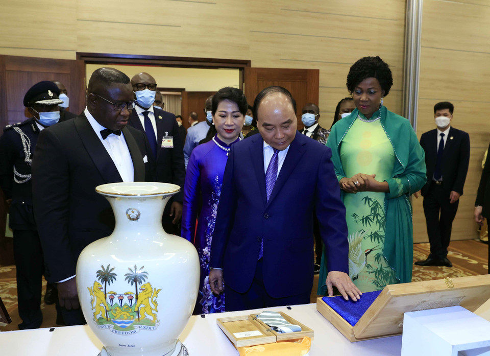 Chủ tịch nước Nguyễn Xuân Phúc giới thiệu với Tổng thống nước Cộng hòa Sierra Leone Julius Maada Bio và Phu nhân về các tặng phẩm. (Ảnh: Thống Nhất/TTXVN)