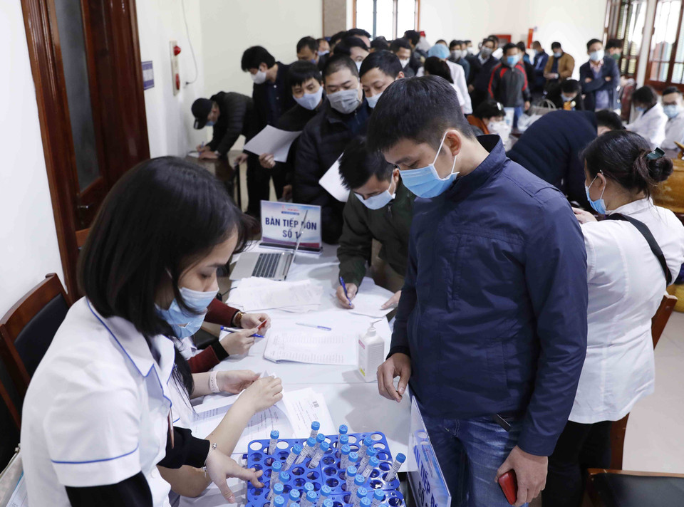 Phóng viên làm thủ tục lẫy mẫu xét nghiệm virus SARS-CoV-2. (Ảnh: Dương Giang/TTXVN)