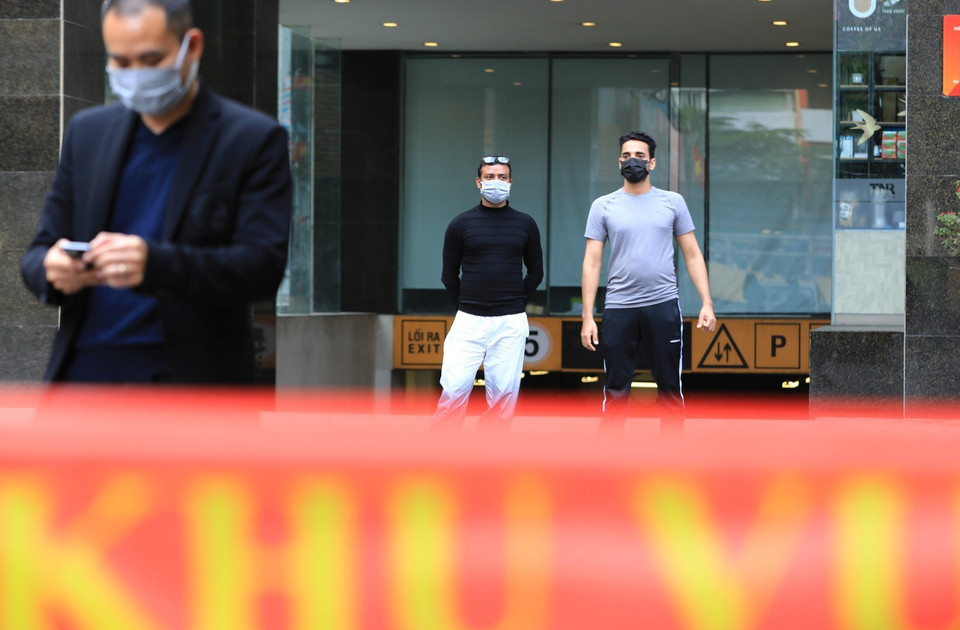 Những người nước ngoài làm việc tại chung cư Sky City Tower chờ đợi đến giờ dỡ bỏ cách ly. (Ảnh: Thành Đạt/TTXVN)