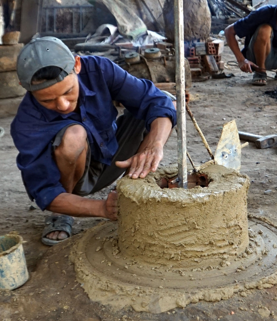 Thợ đúc đồng đang làm khuôn đúc. (Ảnh: Phước Tuệ/TTXVN) 
