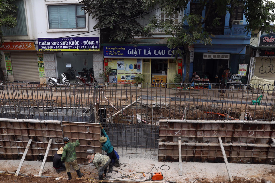 Công nhân thi công tại điểm mở rộng chân đê trên tuyến đường Âu Cơ-Nghi Tàm. (Ảnh: Huy Hùng/TTXVN)