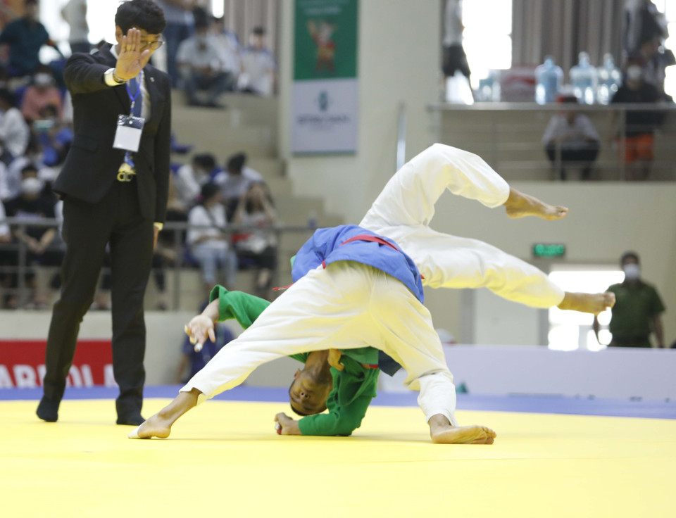 Vận động viên Lê Đức Đồng (xanh dương) với một pha đánh quyết định với vận động viên Saengkaew Natchanon (Thái Lan). (Ảnh: Trần Việt/TTXVN)