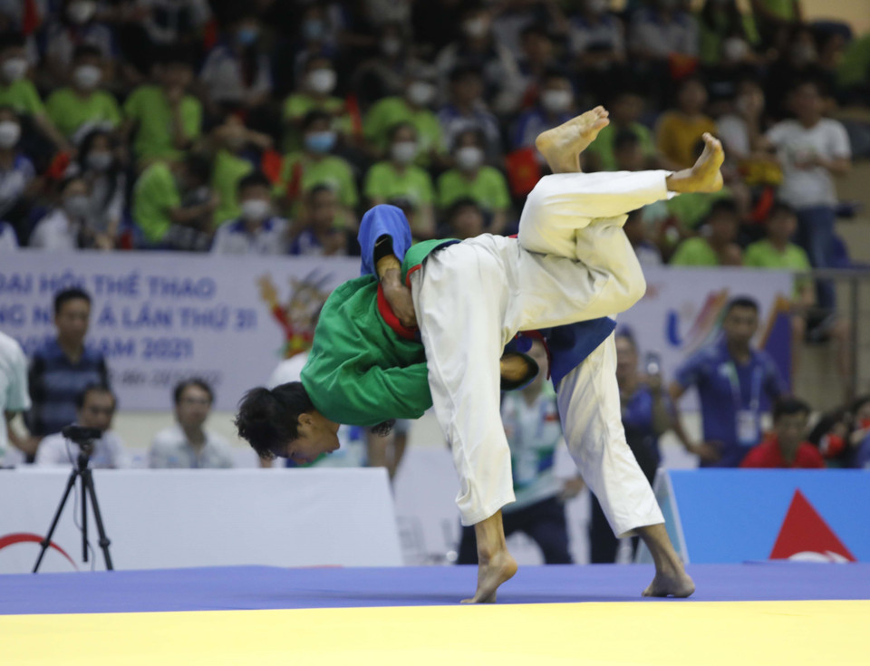 Pha đánh của vận động viên Võ Phạm Hoàng Ân (áo xanh lá cây) và vận động viên Llamas Al Rolan Sorne (Philippines). (Ảnh: Trần Việt/TTXVN)