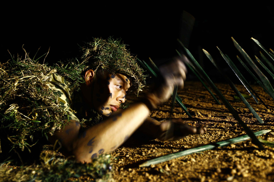 Chiến sỹ Lữ đoàn Đặc công 113 luyện tập vô hiệu hóa từng chiếc chông trong đêm để đồng đội phía sau tiến lên đột nhập căn cứ địch. (Ảnh: An Đăng/TTXVN)