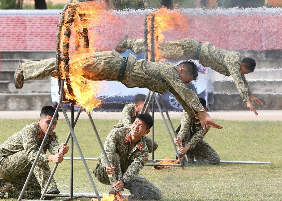 Bộ đội Đặc công trình diễn các kỹ thuật phi thân qua vòng lửa. (Ảnh: Dương Giang/TTXVN)