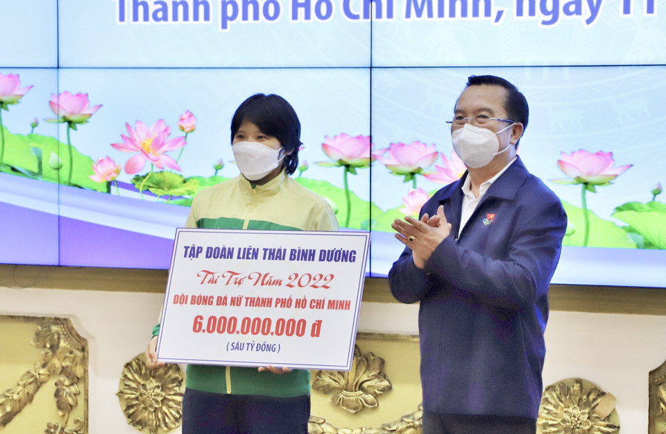 Đại diện các cầu thủ bóng đá nữ Việt Nam nhận bảng tài trợ từ doanh nghiệp. (Ảnh: Hồng Giang/TTXVN)