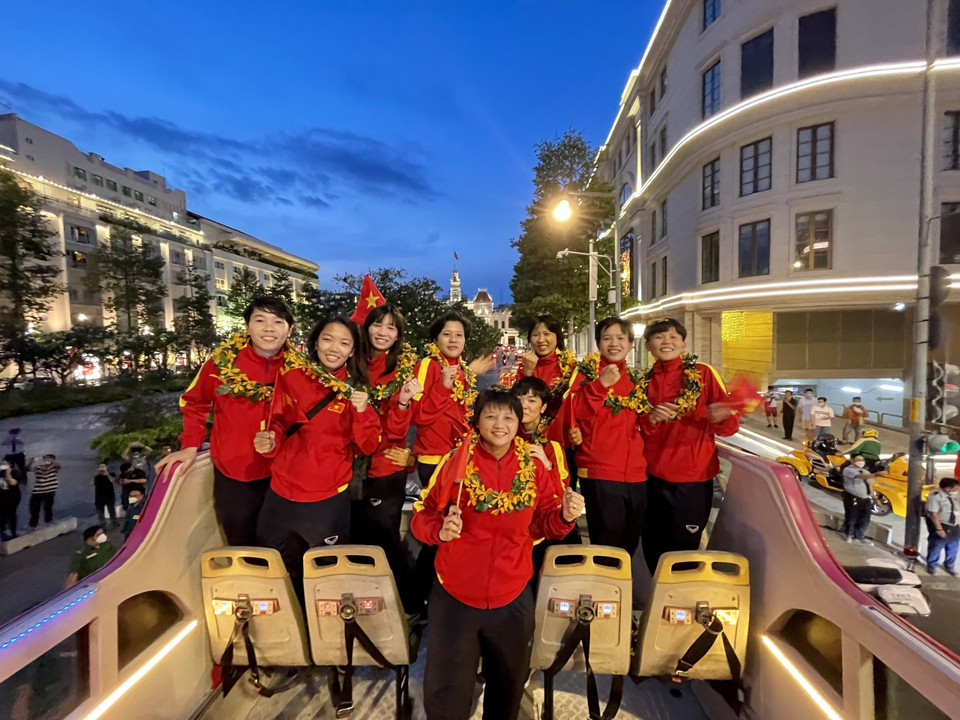 Các thành viên đội tuyển bóng đá nữ Việt Nam diễu hành trên xe buýt 2 tầng. (Ảnh: Hồng Giang/TTXVN)