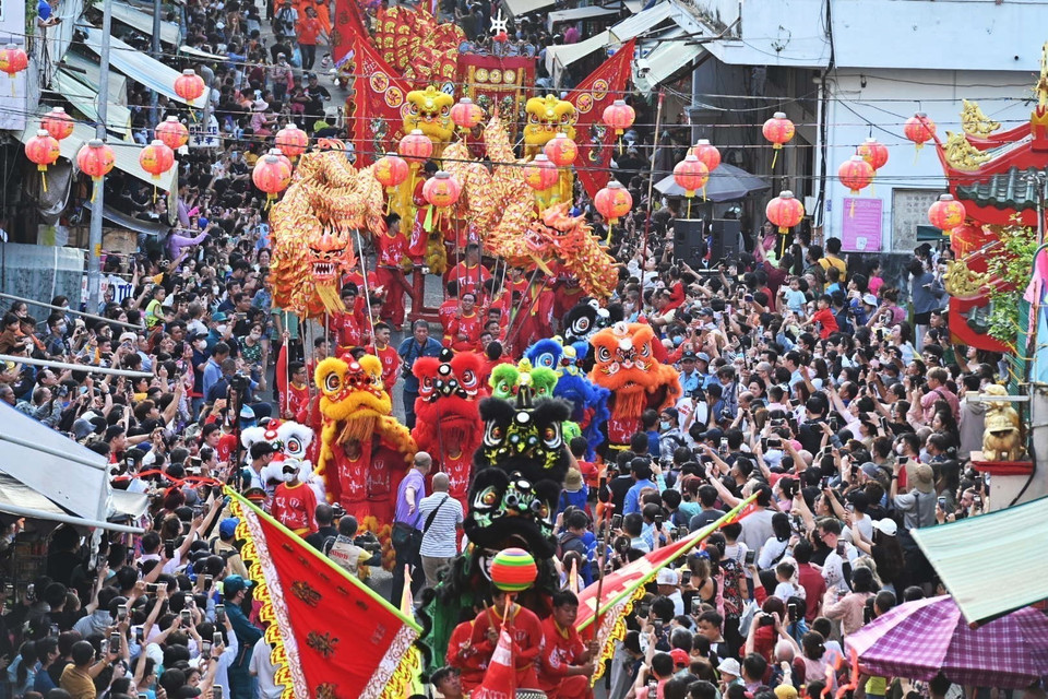 Đông đảo người dân đón chờ đoàn diễu hành đường phố trên đường Lão Tử (Quận 5). (Ảnh: Thu Hương/TTXVN)