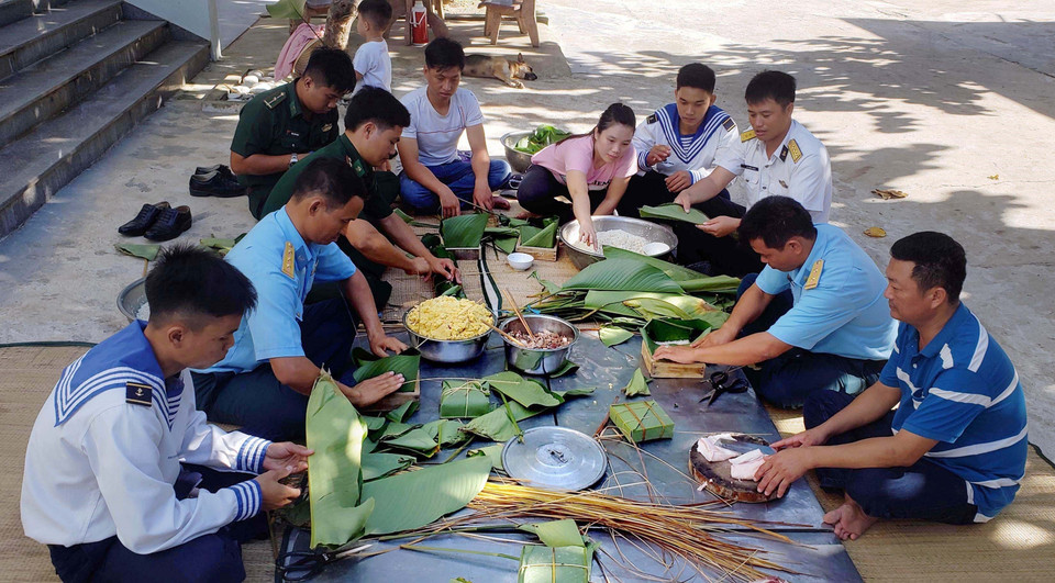  Người dân và cán bộ, chiến sỹ thị trấn Trường Sa quây quần gói bánh chưng, chuẩn bị đón Tết Nguyên đán. (Ảnh: Hoàng Hùng/TTXVN)