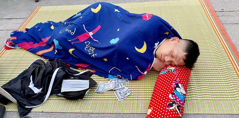 Cổ động viên có giấc ngủ ngon khi nằm chờ phát vé xem trận chung kết giữa Việt Nam-Thái Lan. (Ảnh: Thanh Vân/TTXVN)