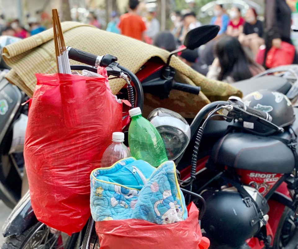 Người dân chuẩn bị sẵn đồ ăn, chiếu nằm chờ sẵn từ tối 20/5 để nhận vé mời xem trận chung kết bóng đá nữ Việt Nan gặp Thái Lan. (Ảnh: Thanh Vân/TTXVN) 