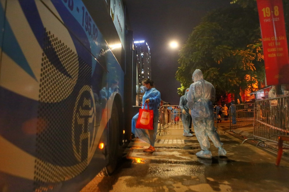 Người dân ngõ 328 và 330 Nguyễn Trãi lên xe, di dời khỏi khu phong toả. (Ảnh: Tuấn Đức/TTXVN)