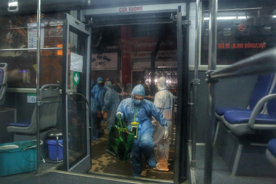 Người dân ngõ 328 và 330 Nguyễn Trãi lên xe, di dời khỏi khu phong toả. (Ảnh: Tuấn Đức/TTXVN)