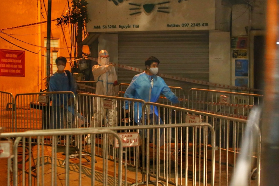 Người dân tại ngõ 328 Nguyễn Trãi di chuyển ra xe. (Ảnh: Tuấn Đức/TTXVN)