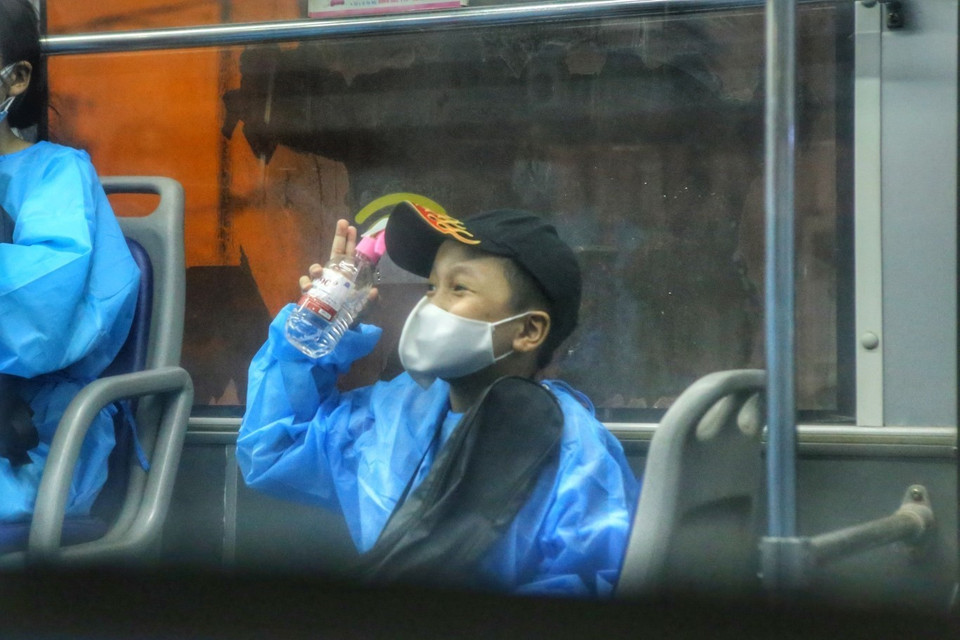 Sự lạc quan của một em nhỏ trên xe khi chuẩn bị dời khu phong toả. (Ảnh: Tuấn Đức/TTXVN)