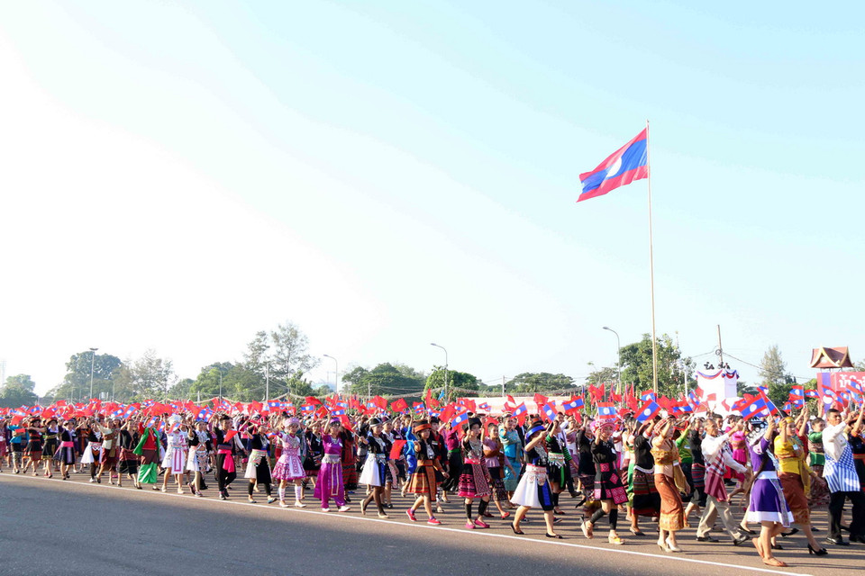 Khối đại diện cho các dân tộc Lào đang tiến qua lễ đài. (Ảnh: Phạm Kiên/Vietnam+)
