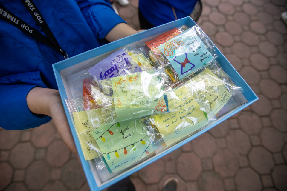 Các tình nguyện viên gửi 'gói lời chúc' tới các sỹ tử. (Ảnh: PV/Vietnam+)