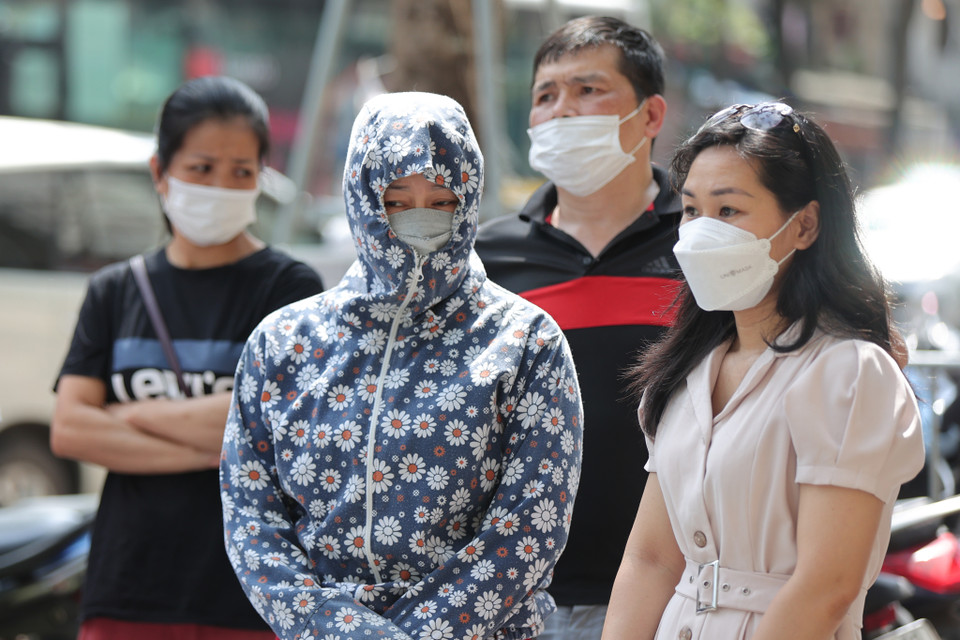 Nhiều bậc phụ huynh đội nắng chờ các con bên ngoài điểm thi. (Ảnh: PV/Vietnam+) 