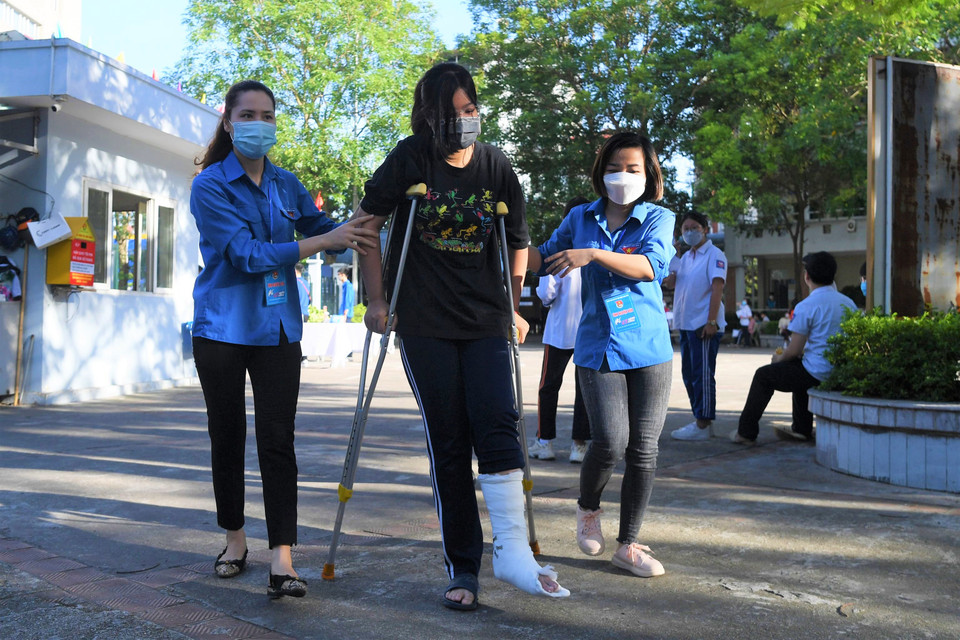 Bạn Lê Thanh Mai, 9A1 trường THCS Ngọc Thụy (quận Long Biên) được mẹ chở đến thi bằng xe máy. Vừa xuống xe, Mai được các bạn tình nguyện viên dìu đến tận phòng thi. “Tuần trước em không may tai nạn gãy chân nên việc di chuyển, học tập có đôi chút khó khăn. Tuy nhiên, được bạn bè, thầy cô và các anh chị tình nguyện viên hết lòng quan tâm, giúp đỡ là động lực để em hoàn thành kỳ thi này,” Mai chia sẻ. (Ảnh: PV/Vietnam+)