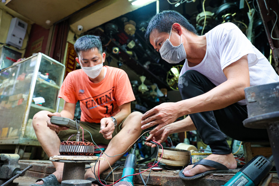 Gắn bó tại đây đã gần 20 năm, anh Nguyễn Văn Ngọc cho biết việc sửa quạt cổ gần như là một phần trong cuộc sống của anh. 'Phục chế một chiếc quạt tưởng như bỏ đi khiến nó sống lại gần như nguyên bản là việc làm vô cùng thích thú. Nó đem lại cho tôi cảm giác chinh phục và say mê,' anh Ngọc chia sẻ. (Ảnh: PV/Vietnam+)