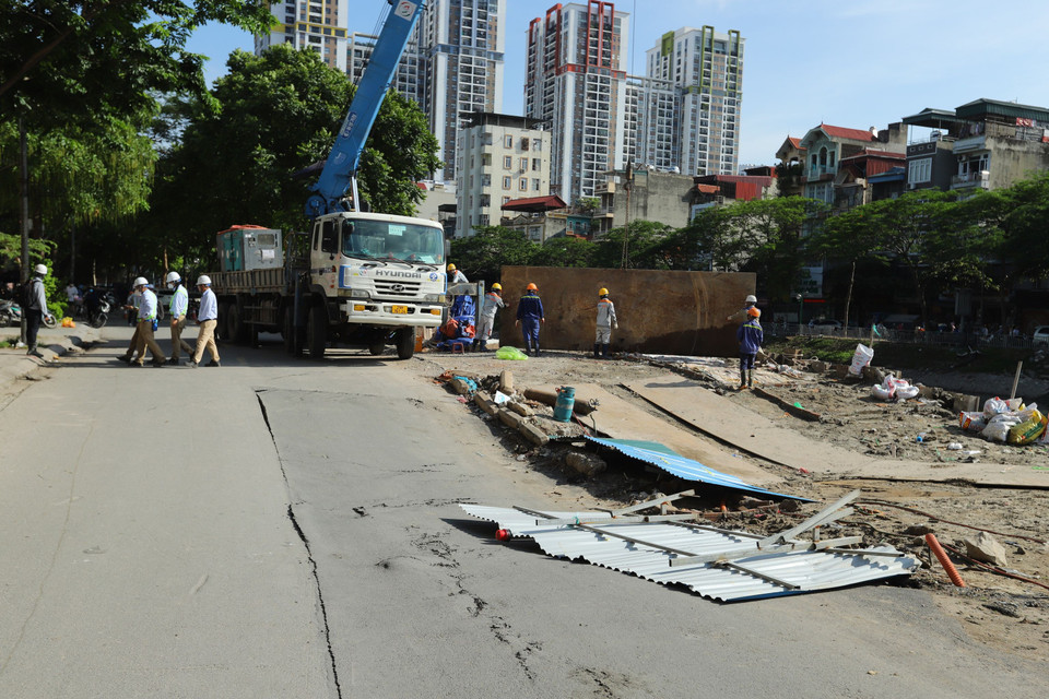 Nhà thầu công trình bên cạnh tuyến đường cũng đã xử lí trước đó. Người dân cho biết trước lúc sụt lún đoạn đường không có dấu hiệu bất thường, đến hơn 14h thì đường dần dần sụt xuống. (Ảnh: Hoài Nam/Vietnam+)