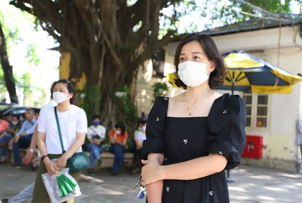 Chị Phạm Ngọc Dung (Kim Ngưu, quận Hai Bà Trưng) đứng nán lại đợi con phía bên ngoài trường. Chị cho biết: “Tôi có dặn con vào phòng thi phải luôn bình tĩnh, không hồi hộp nhưng tôi đứng bên ngoài lại cảm thấy rất lo lắng,” chị Dung cho hay. (Ảnh: PV/Vietnam+)