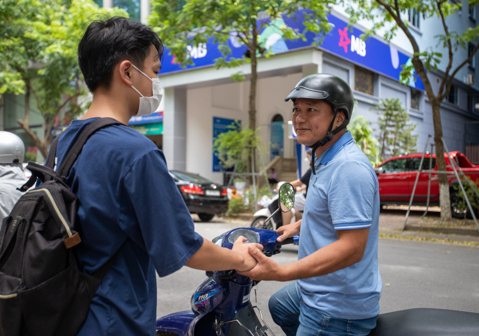 Một phụ huynh đang bắt tay con truyền sự động viên, năng lượng cho môn thi sắp tới. (Ảnh: PV/Vietnam+)