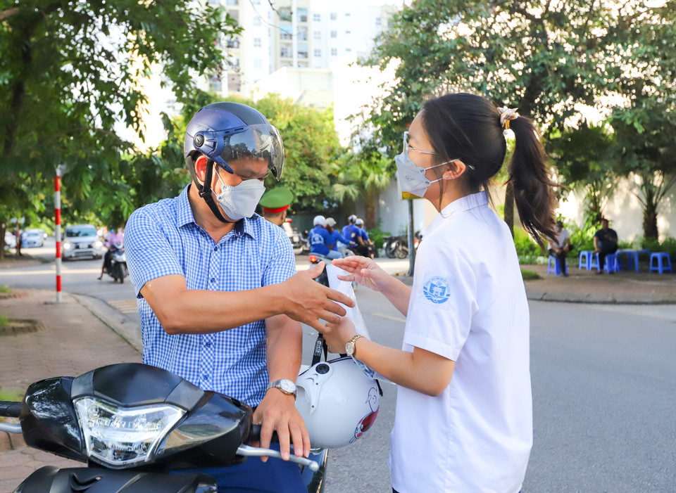 Thời tiết hôm nay tiếp tục nắng nóng nhưng hầu hết các bậc phụ huynh đều ở lại cổng trường đợi con. Đưa con đi thi, họ đều động viên con bình tĩnh, tự tin để hoàn thành tốt bài thi. Nụ cười, một cái ôm, cái đập tay... cũng đủ để tiếp thêm sức mạnh cho các sỹ tử trước những giây phút quan trọng. (Ảnh: PV/Vietnam+)