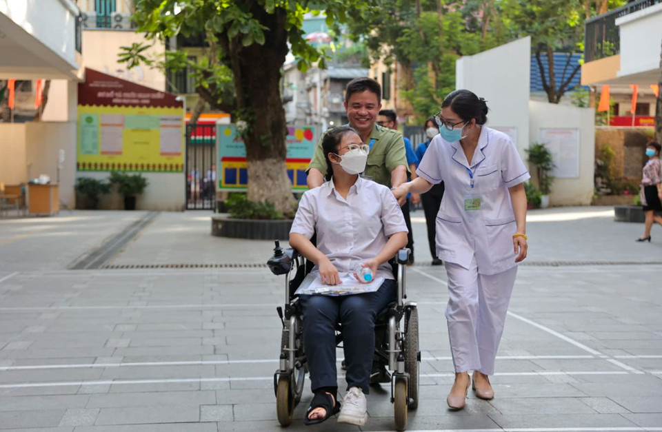 Tại điểm thi này có thí sinh bị gãy chân được nhân viên y tế và cán bộ tại điểm thi đưa vào phòng thi. (Ảnh: PV/Vietnam+) 