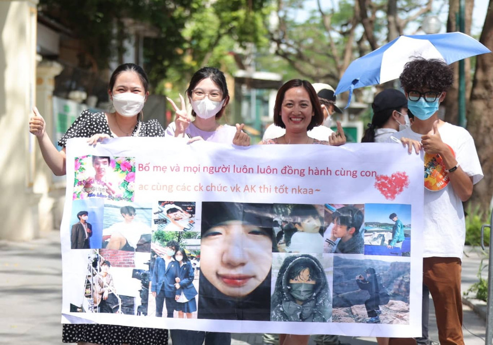 Gia đình sỹ tử mang băng rôn đến chào đón các con sau buổi thi môn cuối cùng. (Ảnh: PV/Vietnam+)