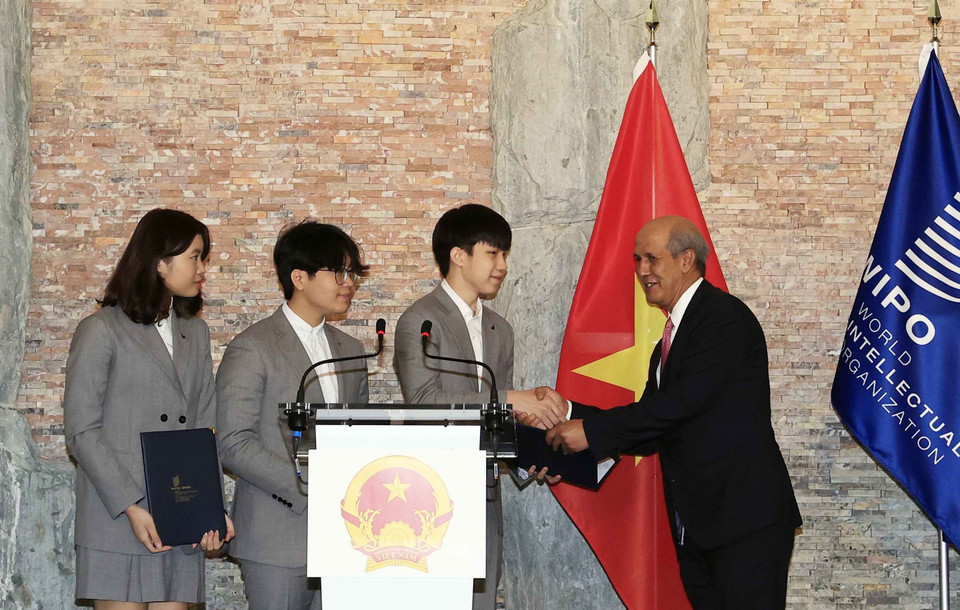 Đại diện Tổ chức sở hữu Trí tuệ Thế giới (WIPO) trao danh hiệu Đại sứ trẻ sở hữu trí tuệ của WIPO cho nhóm các nhà sáng chế trẻ mũ Vihelm (mũ chống Covid 19). (Ảnh: Thống Nhất/TTXVN) 