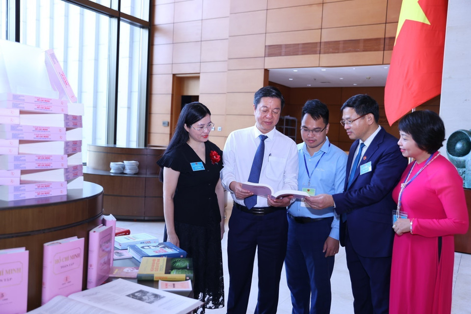 Các đại biểu xem cuốn sách "55 năm thực hiện Di chúc của Chủ tịch Hồ Chí Minh trong các cơ quan Trung ương (1969-2024)” trưng bày tại Hội thảo. (Ảnh: Văn Điệp/ TTXVN)