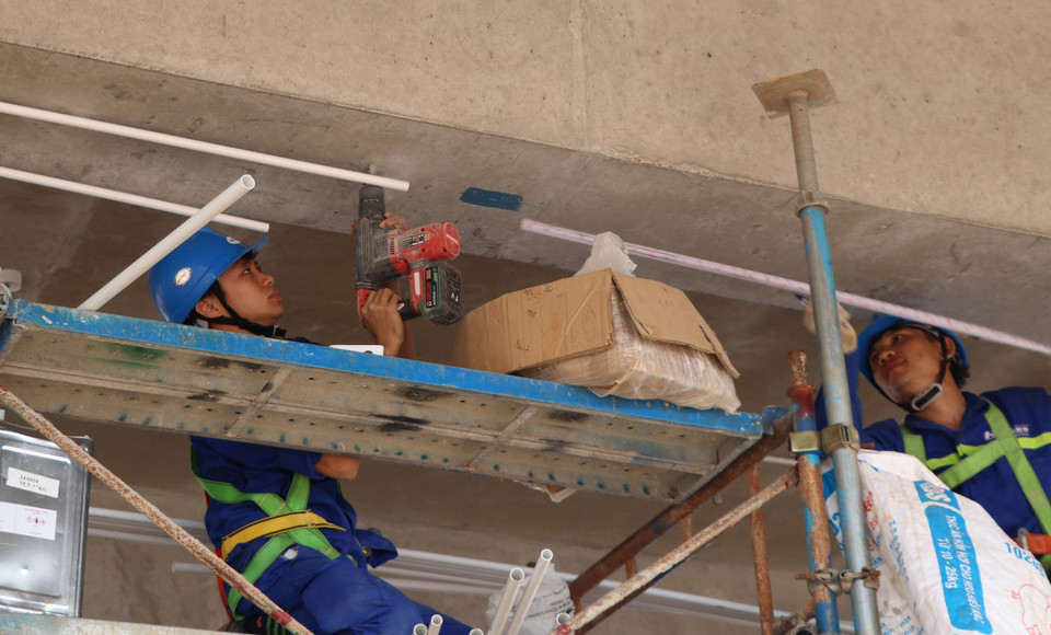 Công nhân lắp ống để đấu nối thiết bị tại nhà ga sân bay Long Thành. (Ảnh: Công Phong/TTXVN)