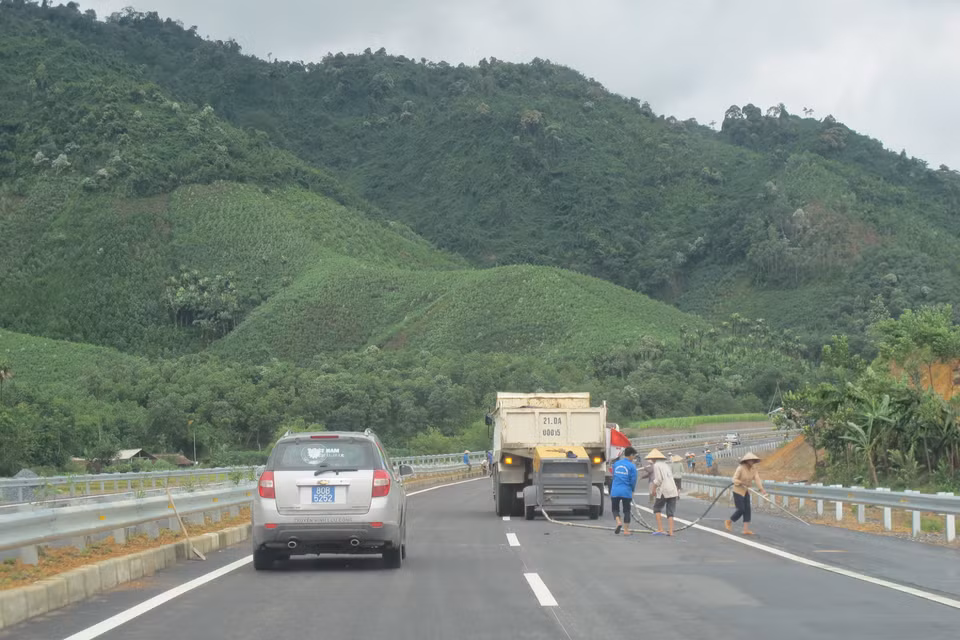 Công nhân tiến hành quét dọn, rửa đường để chuẩn bị cho lễ thông xe. (Ảnh: Việt Hùng/Vietnam+)