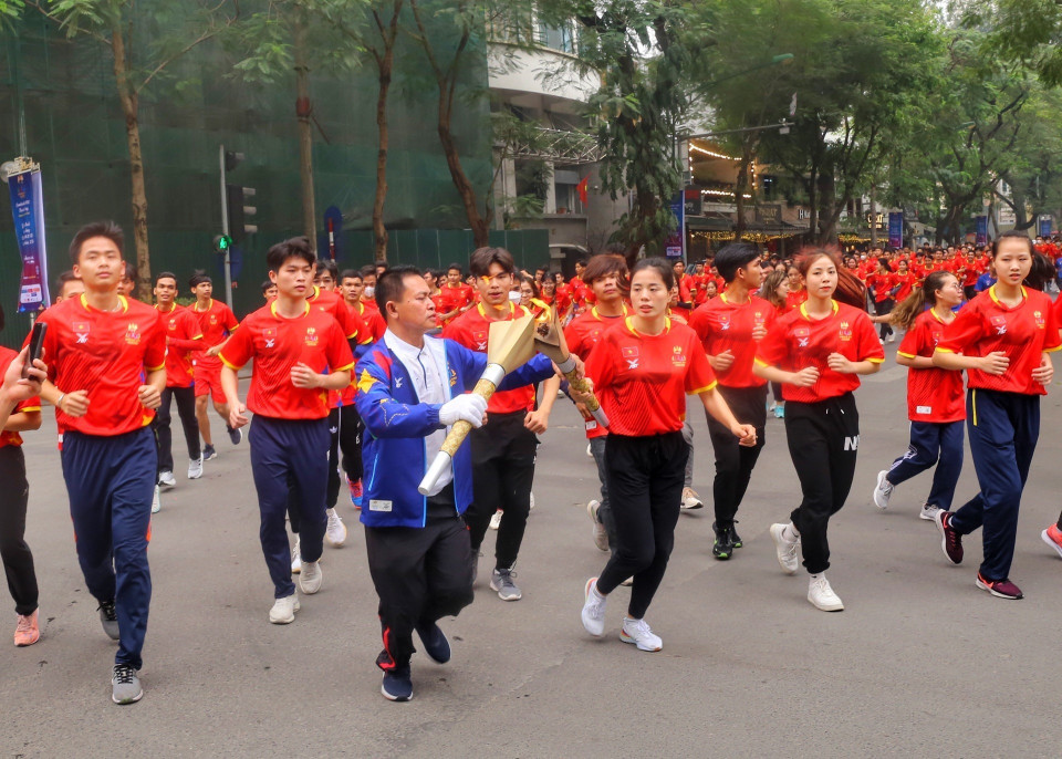 Tiếp lửa cho đoàn rước đuốc trên đường phố Hà Nội. (Ảnh: Tuấn Đức/TTXVN)