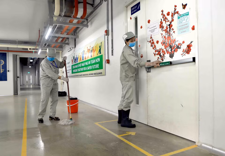 Lau sàn nhà và tay nắm cửa bằng dung dịch sát khuẩn tại Công ty TNHH sản xuất hàng may mặc Việt Nam (TAL), khu công nghiệp Bá Thiện 2 (huyện Bình Xuyên). (Ảnh: Hoàng Hùng/TTXVN)