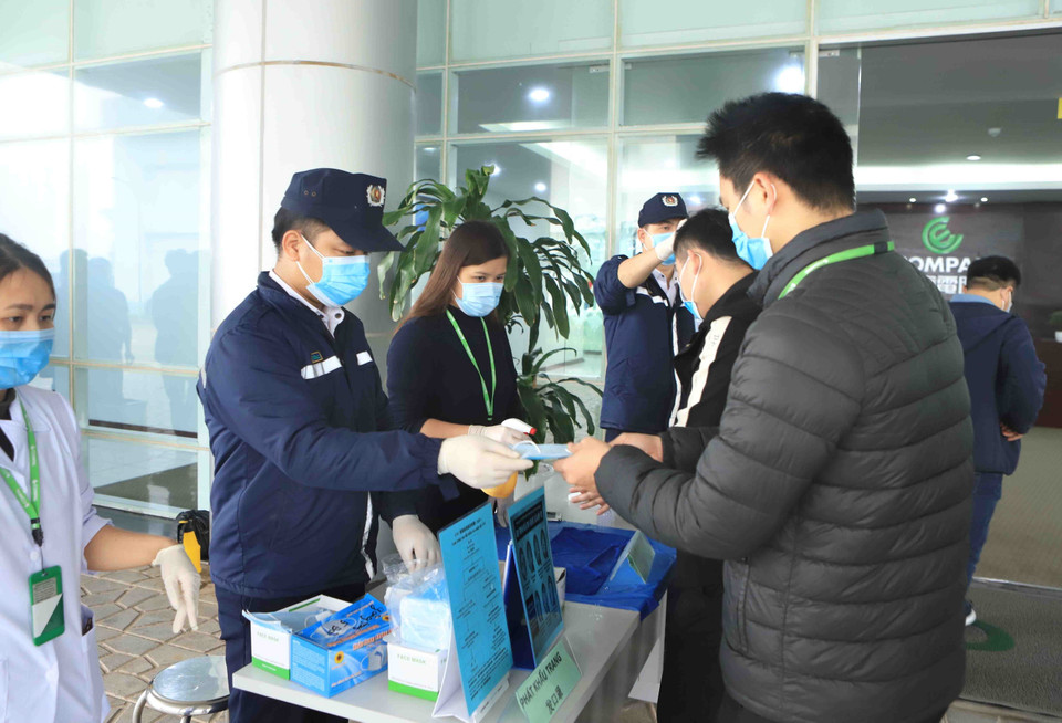 Công ty TNHH Compal Việt Nam trong khu công nghiệp Bá Thiện 1 (huyện Bình Xuyên) phát khẩu trang mới cho cán bộ, công nhân trước khi vào làm việc. (Ảnh: Hoàng Hùng/TTXVN)