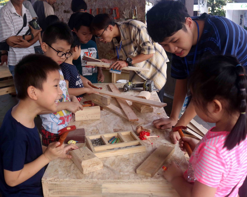 Các em nhỏ được trực tiếp tham gia sáng tạo, làm nên các sản phẩm từ gỗ. (Ảnh: Thanh Tùng/TTXVN)