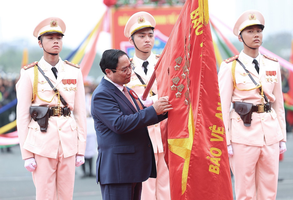 Thủ tướng Phạm Minh Chính gắn Danh hiệu Anh hùng Lực lượng Vũ trang Nhân dân lên cờ truyền thống của lực lượng Cảnh sát Cơ động. (Ảnh: Dương Giang/TTXVN)