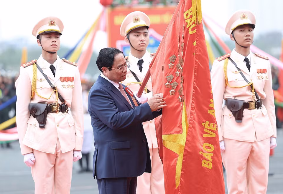 Thủ tướng Phạm Minh Chính gắn Danh hiệu Anh hùng Lực lượng Vũ trang Nhân dân lên cờ truyền thống của lực lượng Cảnh sát Cơ động. (Ảnh: Dương Giang/TTXVN)