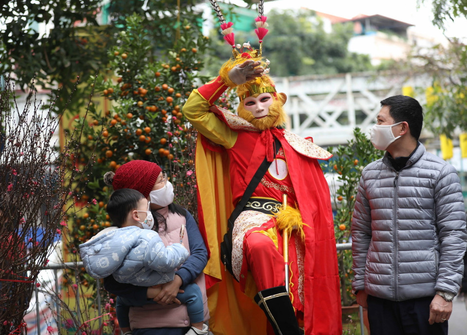 Hóa thân vào hình tượng Tôn Ngộ Không thu hút sự chú ý của các em nhỏ khi được cùng bố mẹ đưa tới chợ hoa Hàng Lược. (Ảnh: Thanh Tùng/TTXVN)